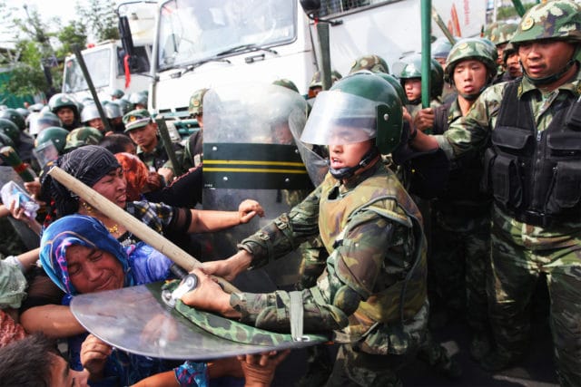 OPTIMIZED REPRESSION 
Chinese policemen push Uyghur women who are protesting in Ürümqi, the capital of the Xinjiang Uyghur Autonomous Region, China, on July 7, 2009. Hundreds of Uyghur people protested after their relatives were detained by authorities.