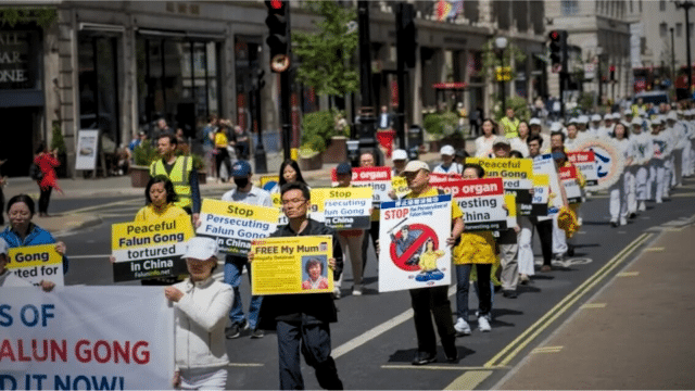 Hu Xuanming (2nd row, R), whose mother is imprisoned in China, marching in a rally commemorating the 24th anniversary of the Chinese regime's ongoing persecution of Falun Gong, in London on July 15, 2023. (via Yanning Qi/The Epoch Times)